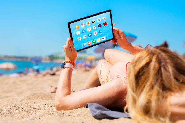 Woman,Using,Tablet,Computer,While,Relaxing,And,Sunbathing,In,Bikini