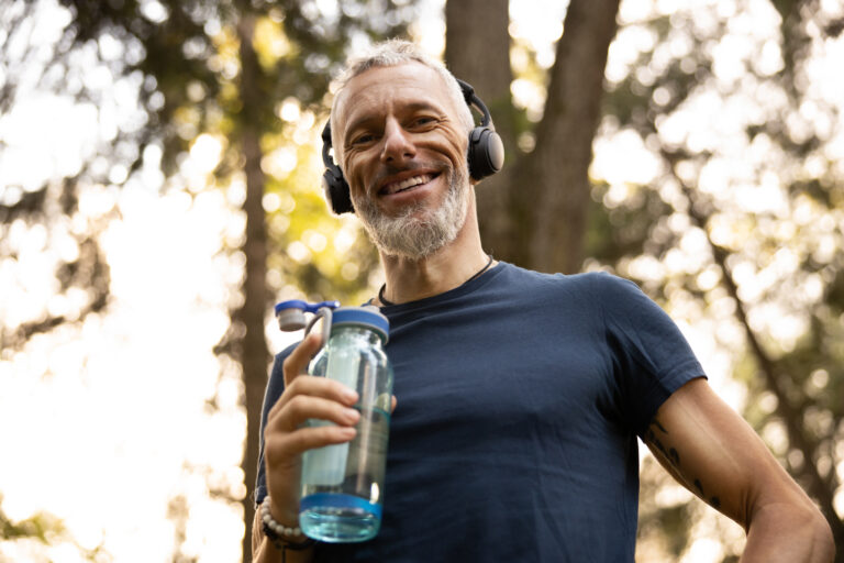 Low,Angle,Portrait,Of,Joyful,Grizzled,Athletic,Male,Drinking,Water